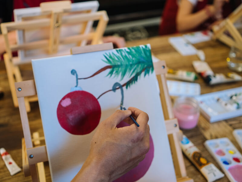 A canvas with a festive painted bauble from a team building paint and sip class